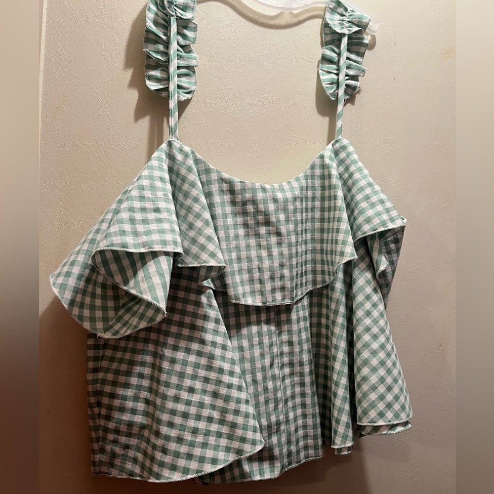 Flowy green tank top with gingham pattern and ruffle straps.
